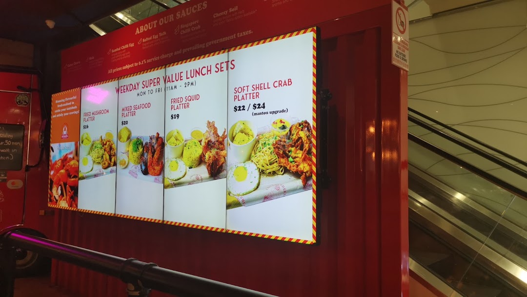 A brightly lit menu board for Cajun on Wheels, showcasing weekday super value lunch sets and sauce options.