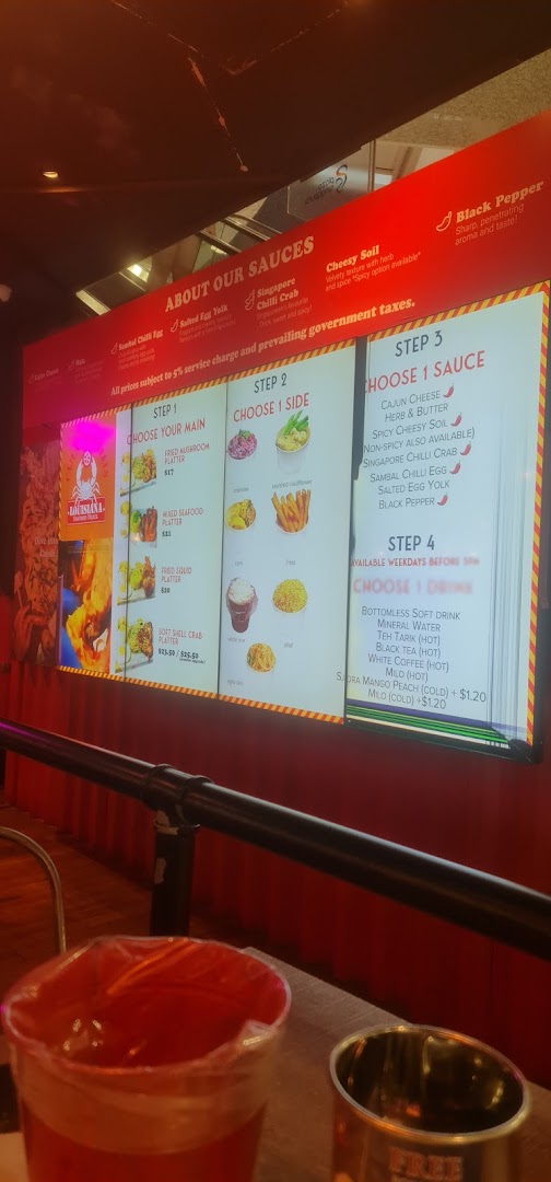 A digital menu board displaying customizable seafood platters, sauces, sides, and drinks.