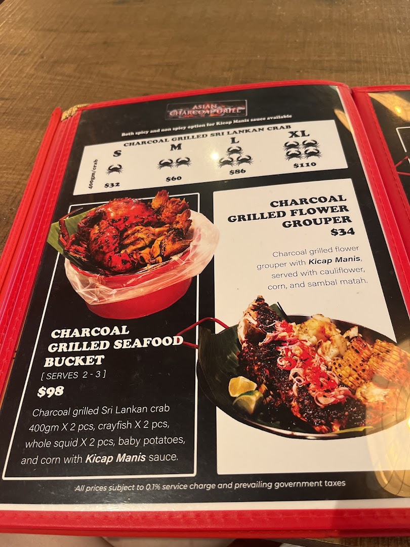 A close-up of a menu displaying charcoal-grilled seafood dishes and prices.