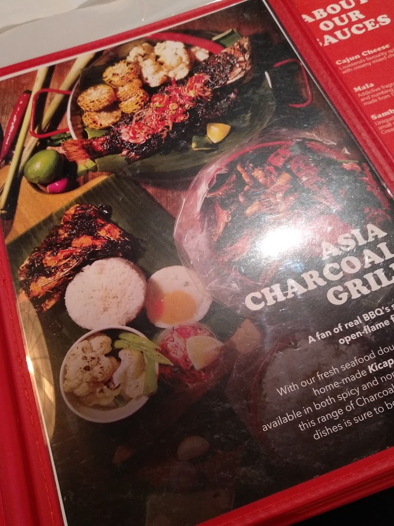 A menu page showcasing grilled seafood and Asian charcoal grill dishes with sauce descriptions.