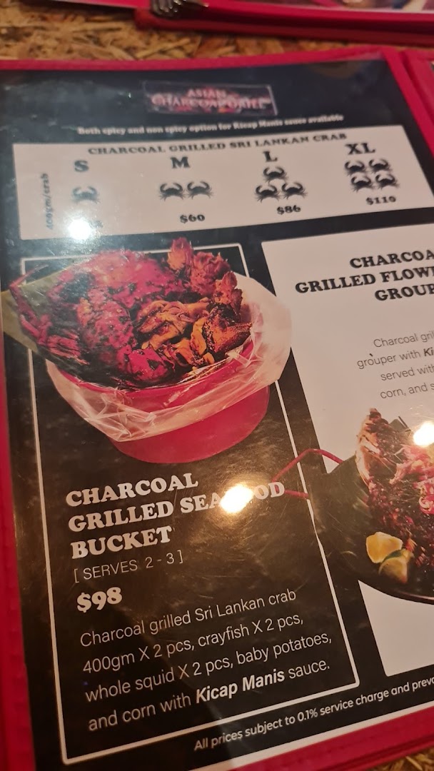 A close-up of a menu page featuring charcoal grilled seafood dishes and prices.