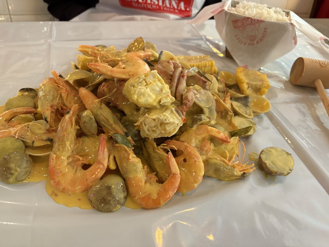 A vibrant close-up of a Cajun seafood boil with shrimp, clams, corn, and potatoes.