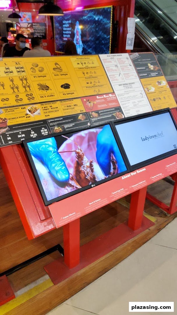 A vibrant display stand showcasing Cajun on Wheels' seafood menu, prices, and sauce options.