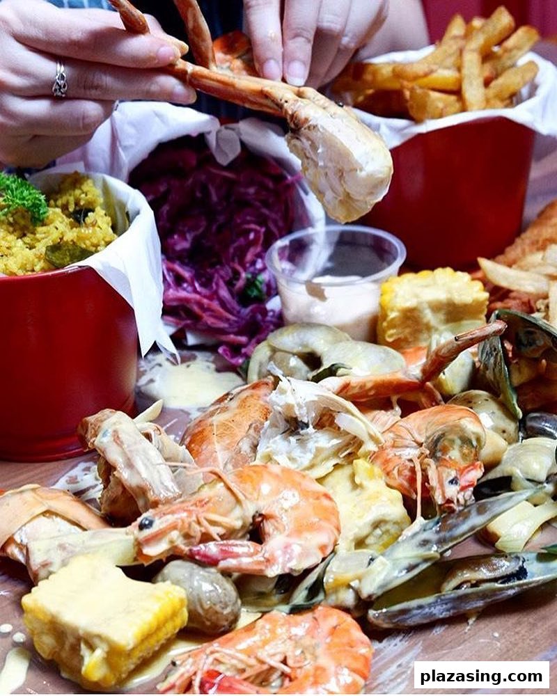 A vibrant close-up of a person enjoying a Cajun seafood boil with crab, shrimp, mussels, and sides.