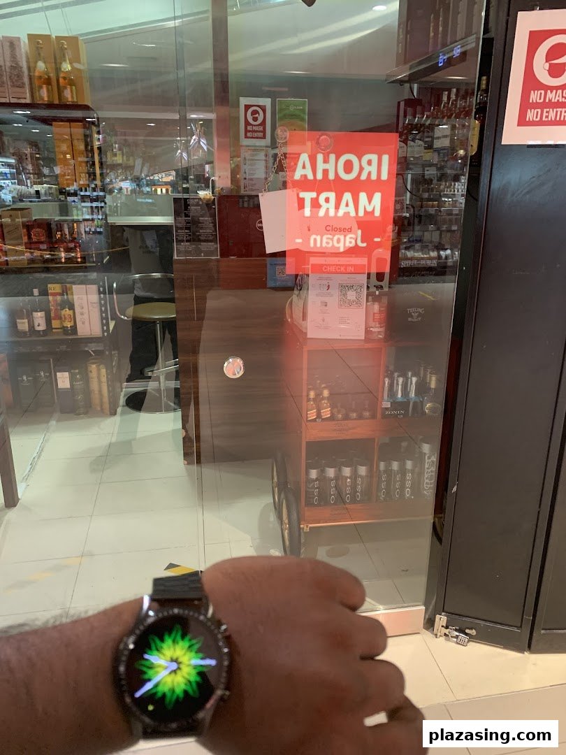 The glass entrance of Cellarbration Liquor & Wine store, with a smartwatch in the foreground.