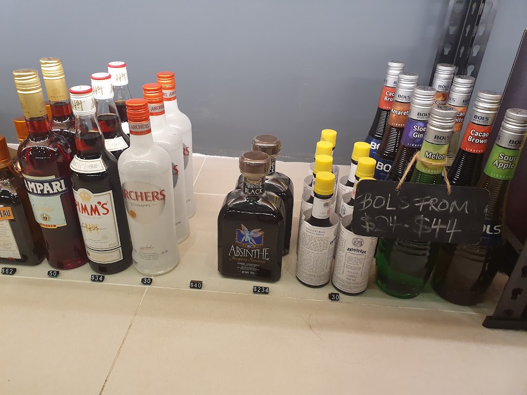 A display of various liquor bottles, including Campari, Pimm's, Archers, Absinthe, and Bols liqueurs, with prices.