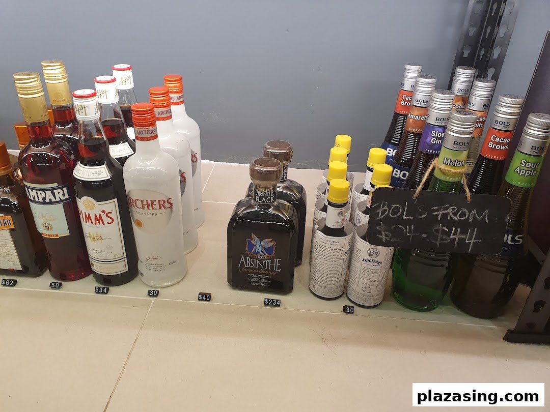 A display of various liquor bottles, including Campari, Pimm's, Archers, Absinthe, and Bols liqueurs, with prices.