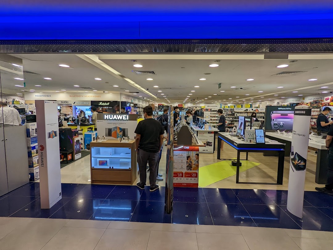 View into Challenger Plaza Singapura, an electronics store featuring headphones, smartphones, and various tech gadgets.