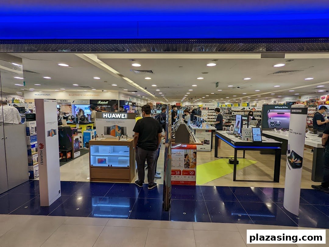 View into Challenger Plaza Singapura, an electronics store featuring headphones, smartphones, and various tech gadgets.