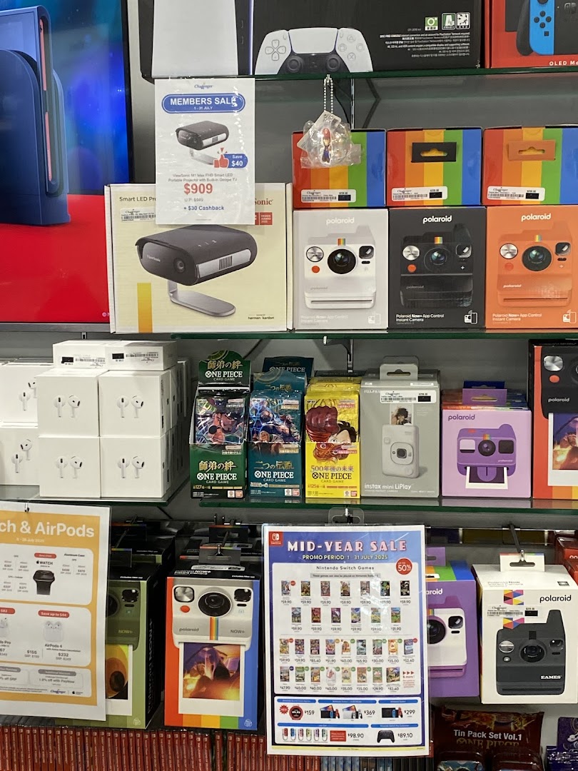 A vibrant display of electronics, including cameras, projectors, and gaming products, on shelves at Challenger.