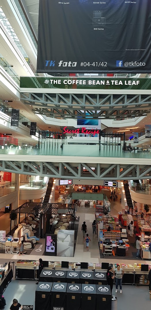 A vibrant multi-level view of a shopping mall interior, showcasing various retail and F&B outlets.