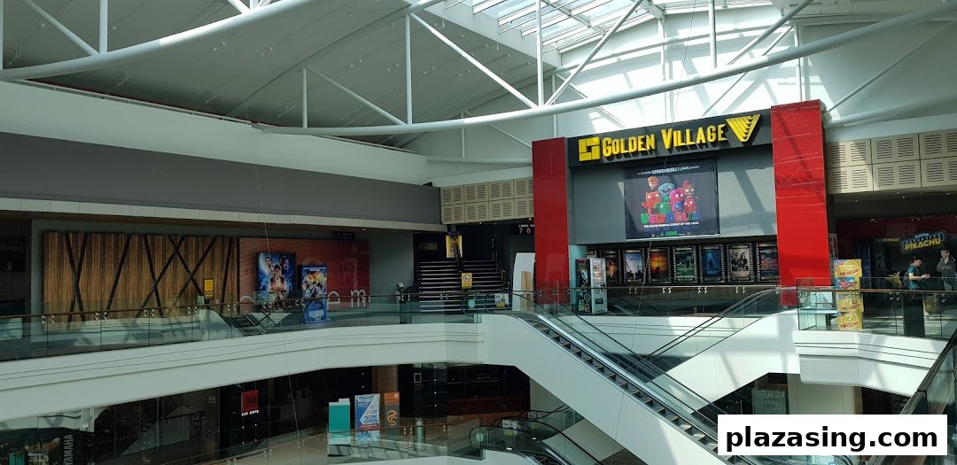 Interior view of a multi-level shopping mall featuring escalators and a Golden Village cinema entrance.