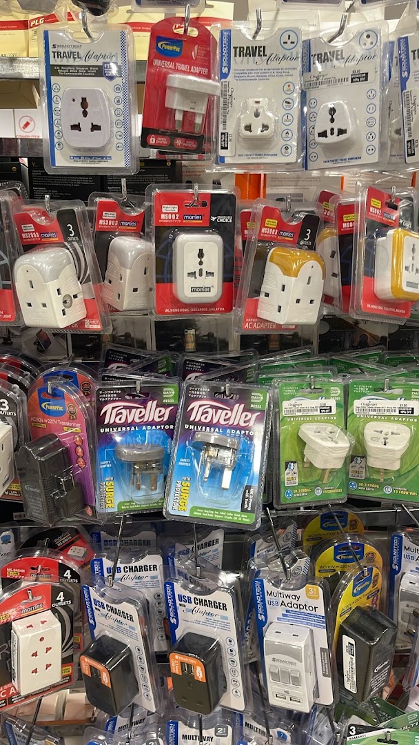 A display of various travel adapters, USB chargers, and multi-way power adaptors for sale.