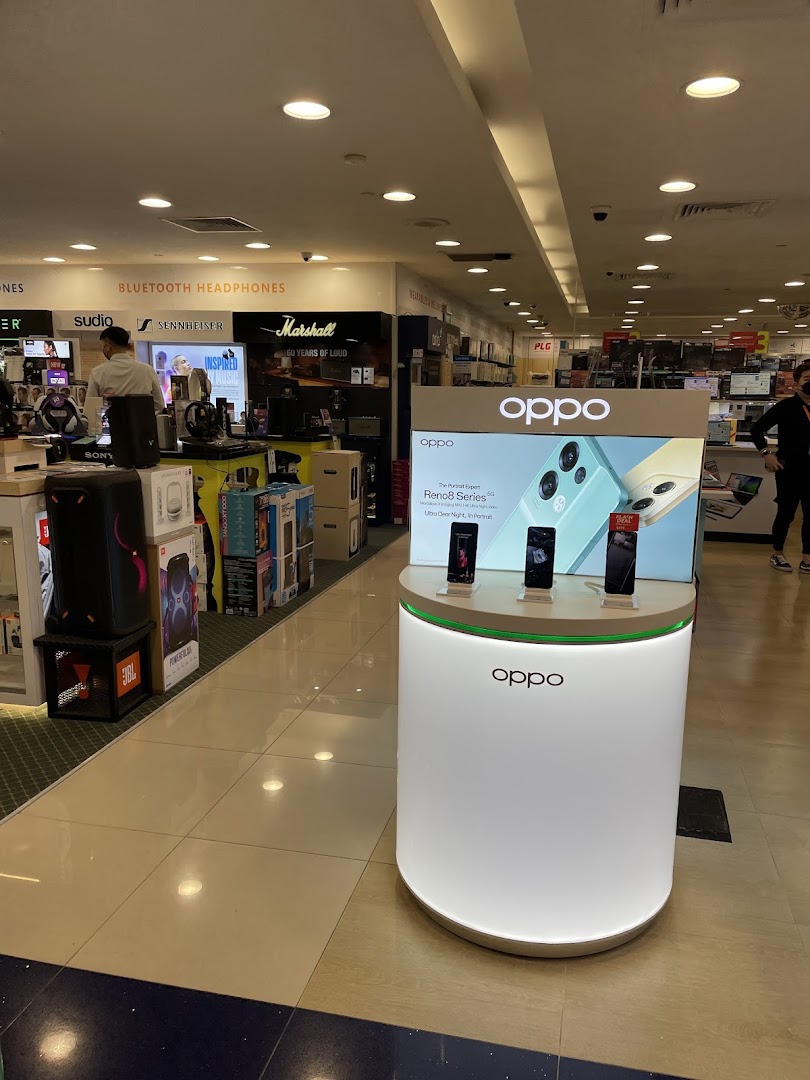 Interior view of Challenger Plaza Singapura, showcasing an OPPO smartphone display and various electronics like headphones.