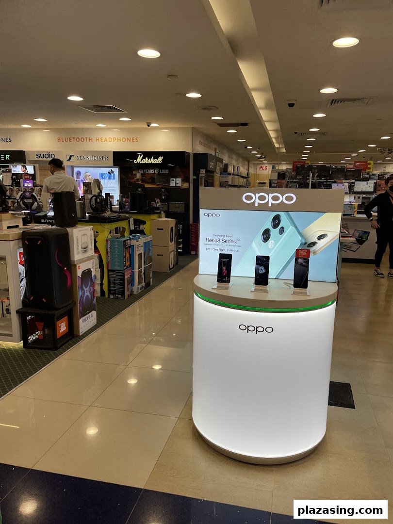 Interior view of Challenger Plaza Singapura, showcasing an OPPO smartphone display and various electronics like headphones.