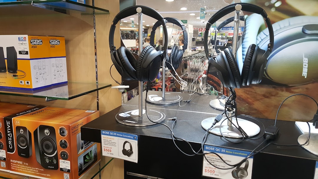 An electronics store display featuring Bose noise-cancelling headphones and Creative speakers.