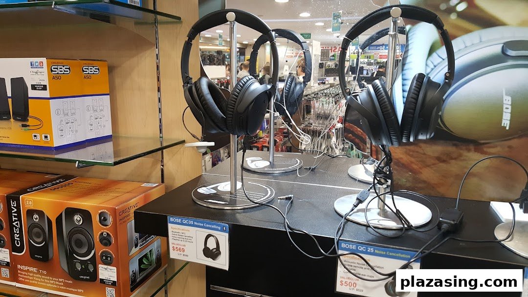 An electronics store display featuring Bose noise-cancelling headphones and Creative speakers.