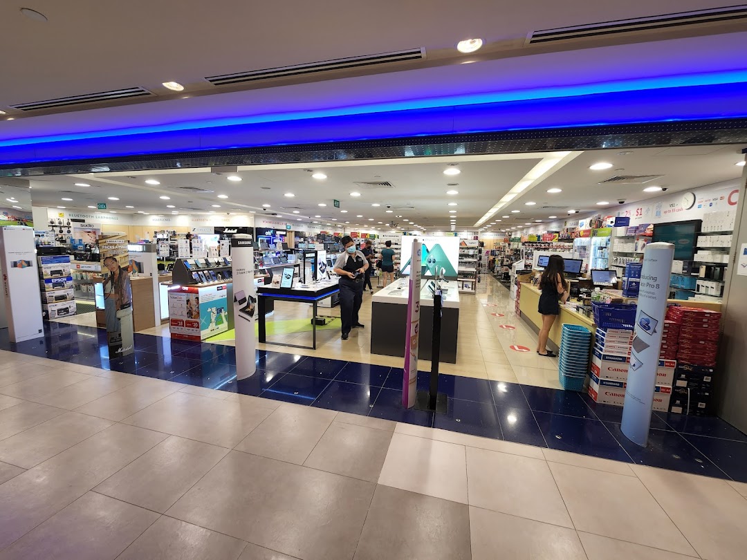 Wide view of Challenger electronics store entrance, showcasing various tech products and staff.