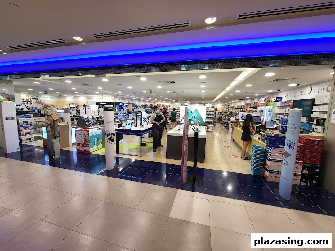 Wide view of Challenger electronics store entrance, showcasing various tech products and staff.