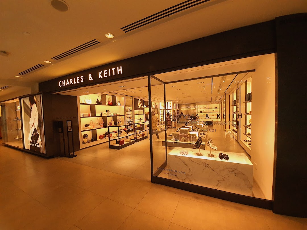 The brightly lit storefront of CHARLES & KEITH showcases a wide array of stylish bags and shoes.
