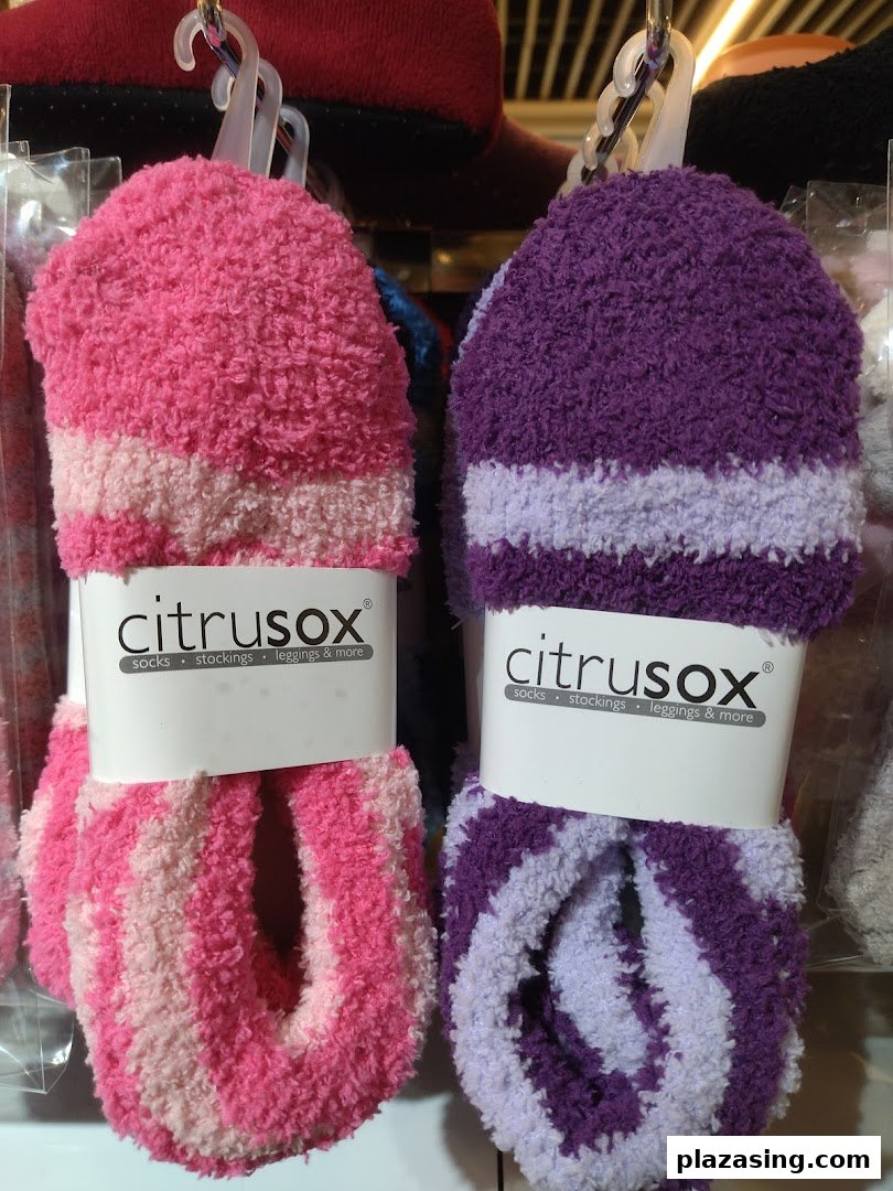 Close-up of two pairs of fluffy, striped Citrusox socks in pink and purple, displayed for sale.