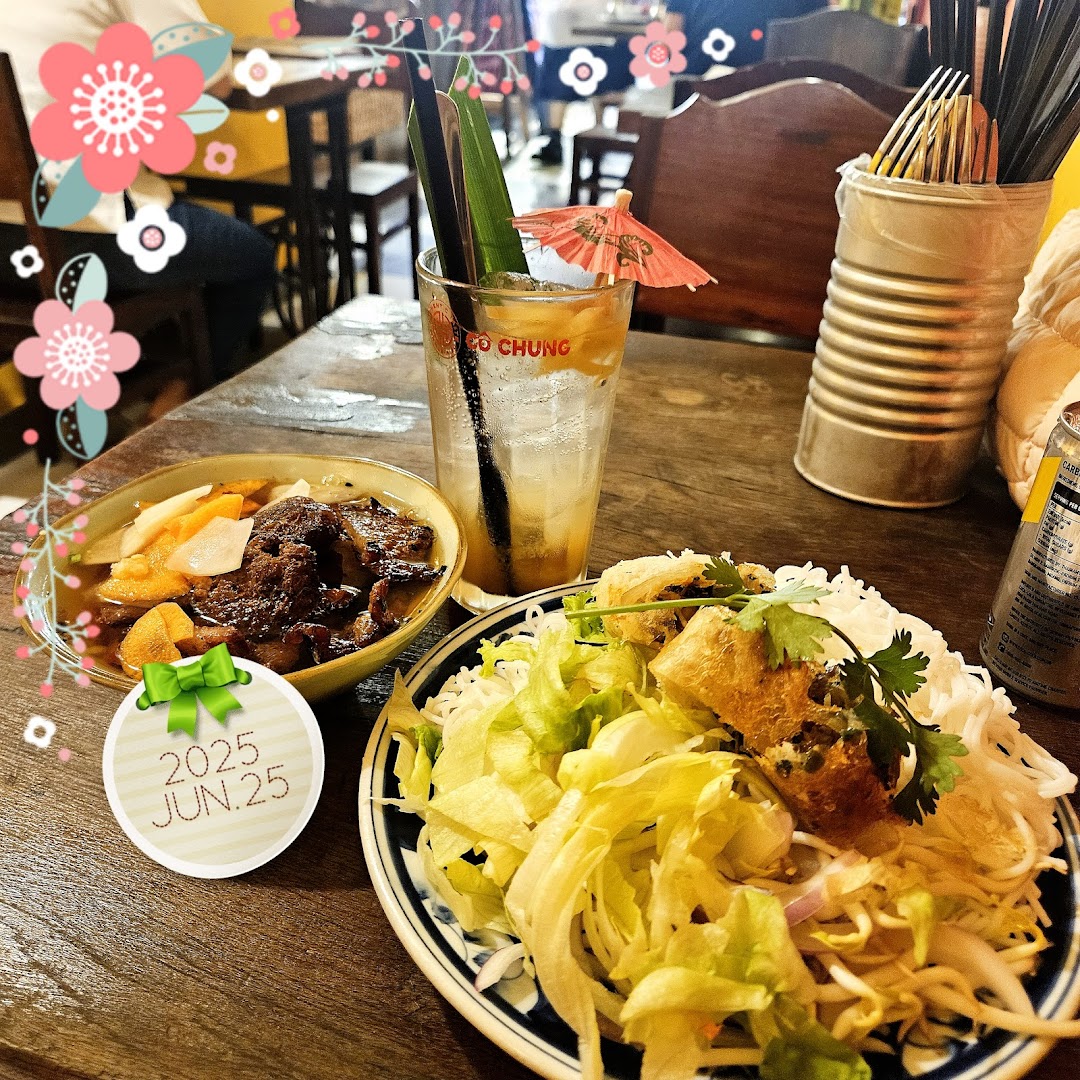 A table laden with authentic Vietnamese dishes, including Bun Cha and vermicelli noodles, alongside a refreshing drink.