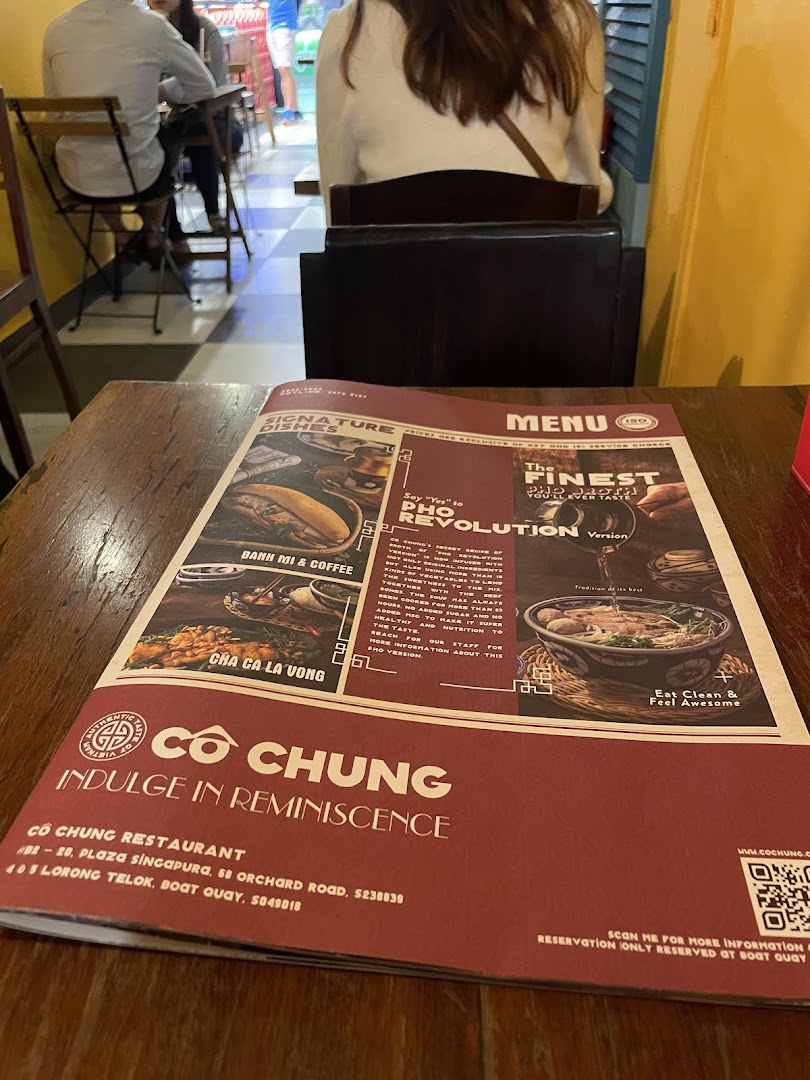 A menu for Co Chung Vietnamese Restaurant displayed on a wooden table.