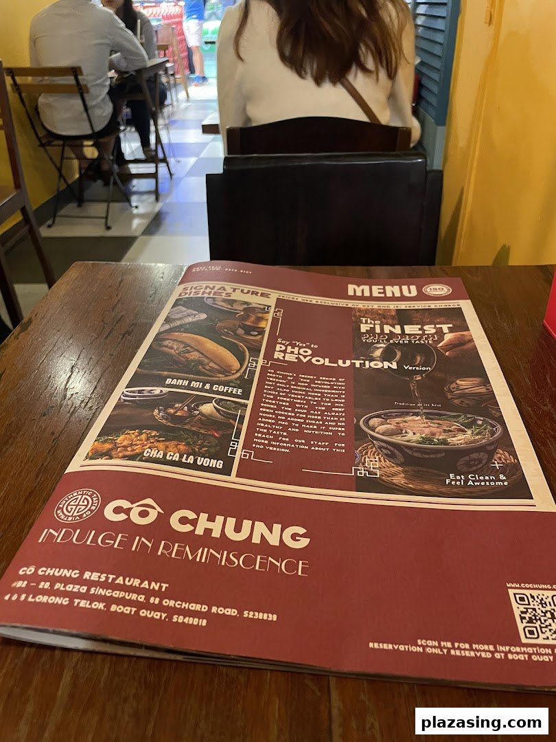 A menu for Co Chung Vietnamese Restaurant displayed on a wooden table.