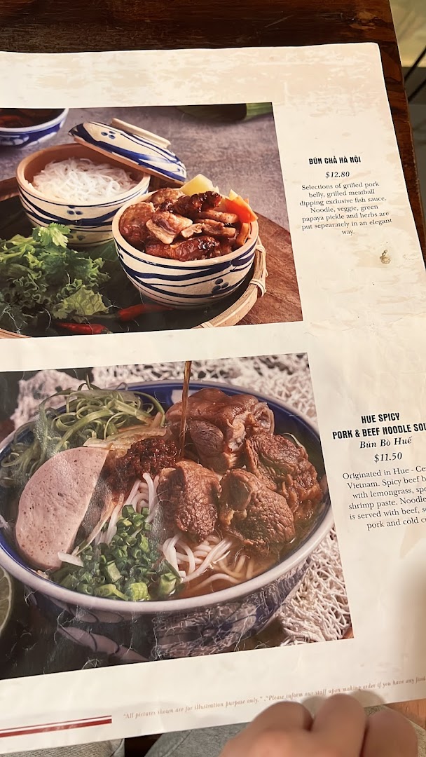 A close-up of a Vietnamese restaurant menu featuring Bún Chả Hà Nội and Bún Bò Huế dishes.