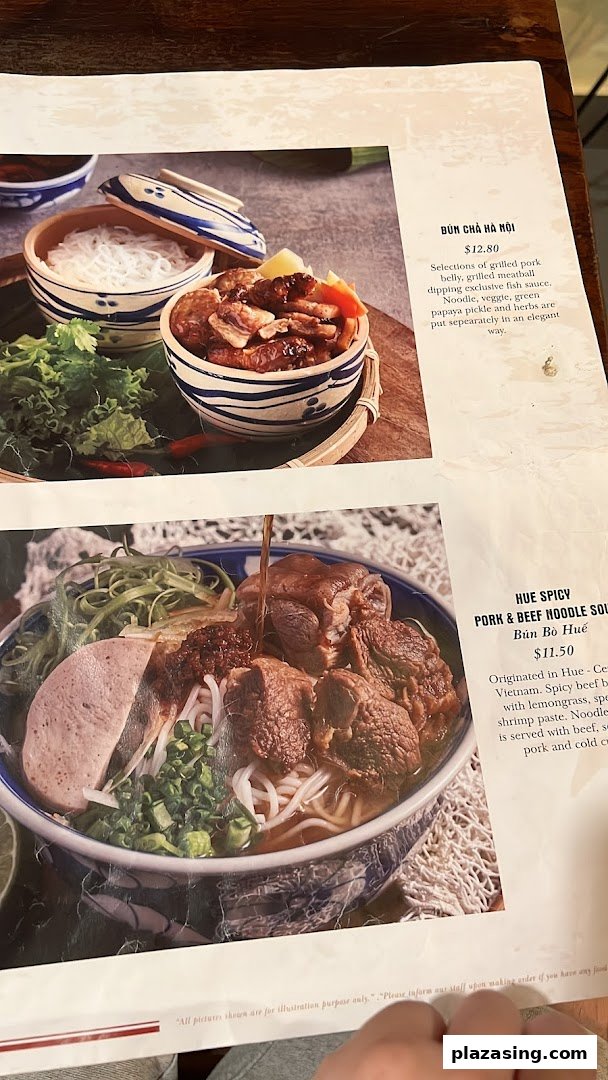 A close-up of a Vietnamese restaurant menu featuring Bún Chả Hà Nội and Bún Bò Huế dishes.