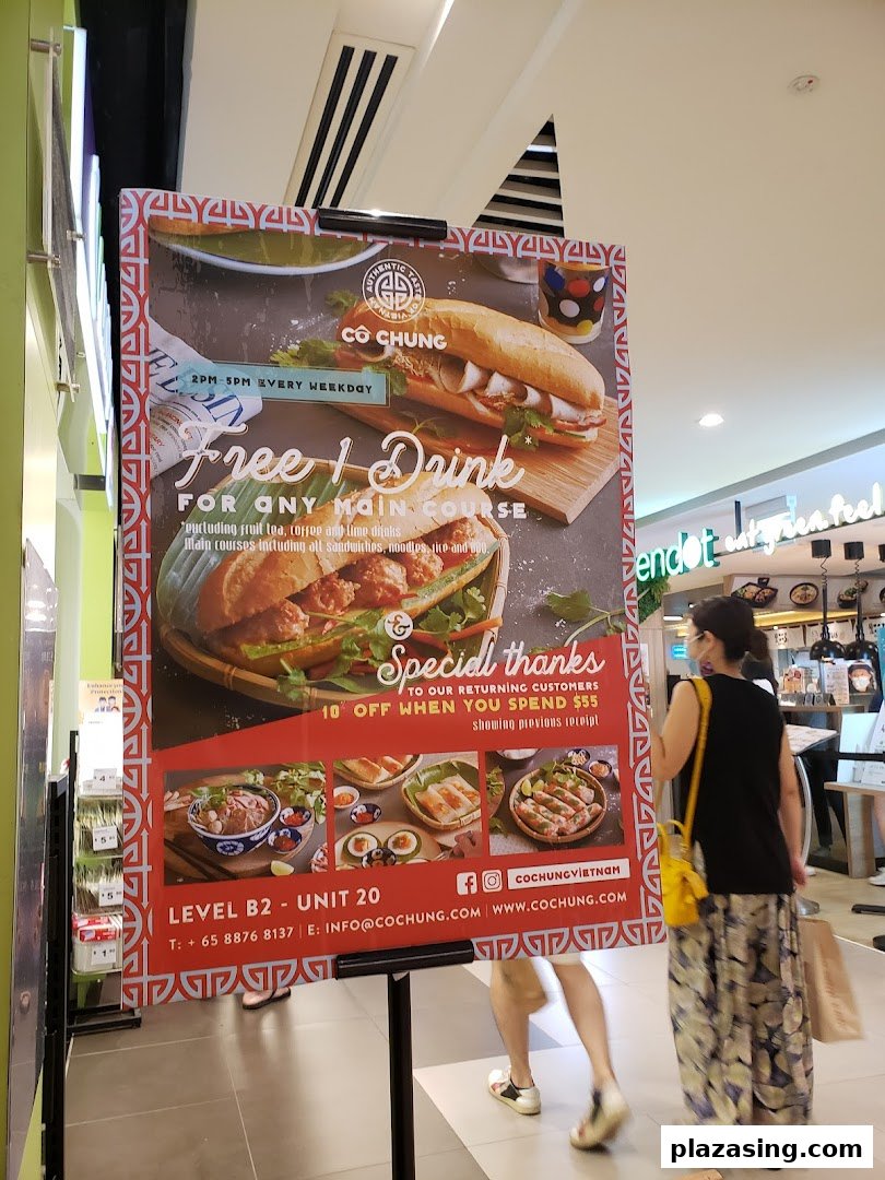A promotional standee for Co Chung Vietnamese Restaurant showcasing food items and special offers.