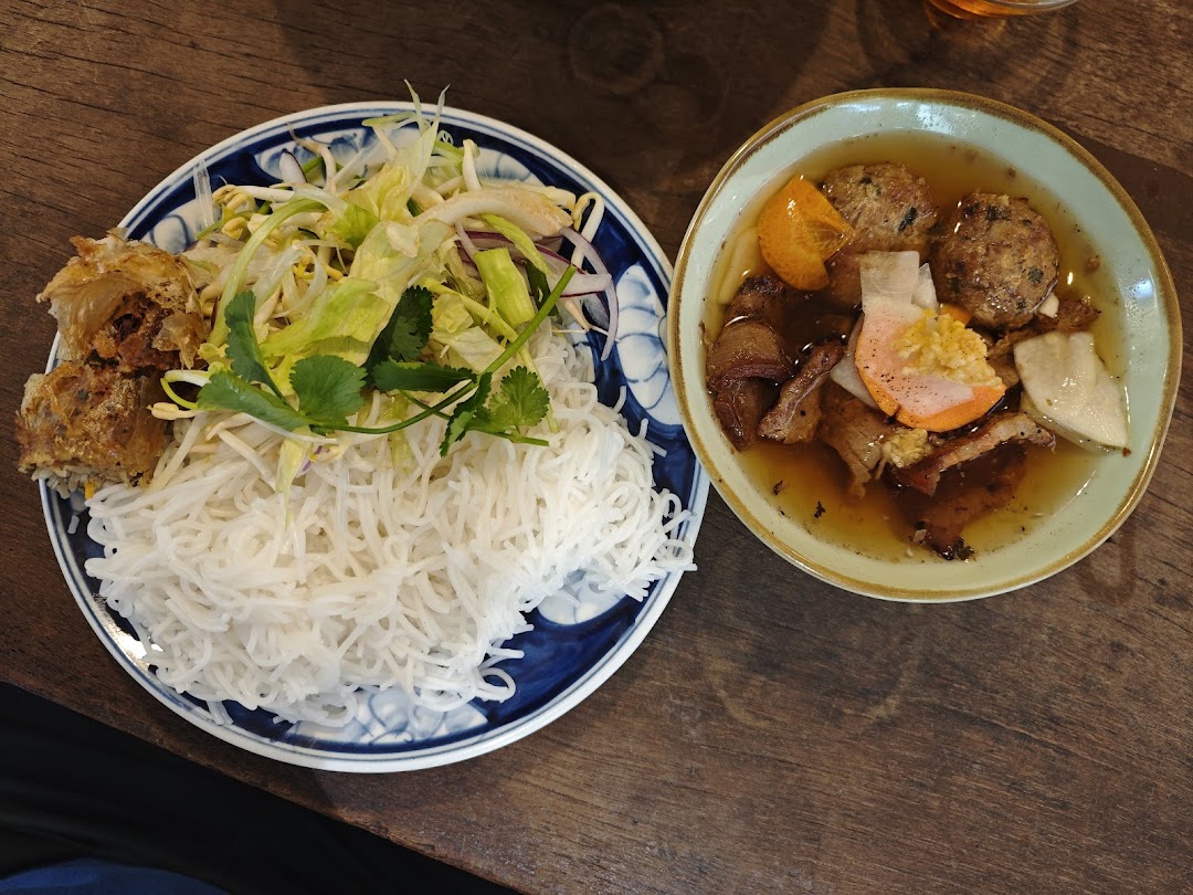 A vibrant Vietnamese dish with rice vermicelli, fresh herbs, spring rolls, and savory broth.