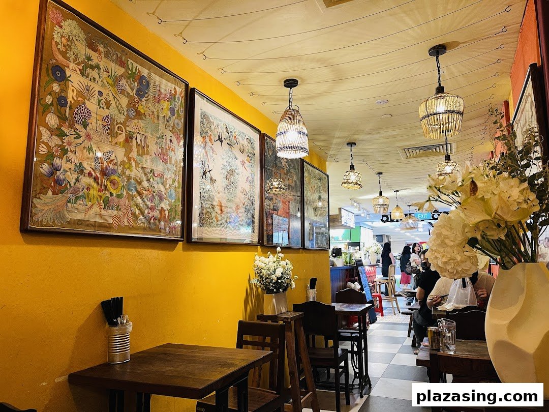 A vibrant interior shot of Co Chung Vietnamese Restaurant, featuring colorful wall art, rattan lighting, and cozy wooden tables.