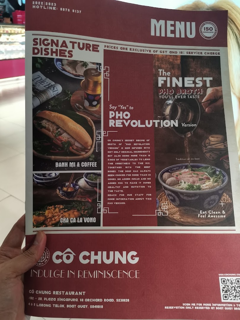 A person holding a menu for Co Chung Vietnamese Restaurant, showcasing signature dishes and pho.