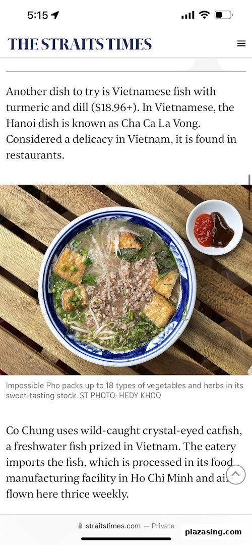 A delicious bowl of Vietnamese Impossible Pho with various ingredients and sauces on a wooden table.
