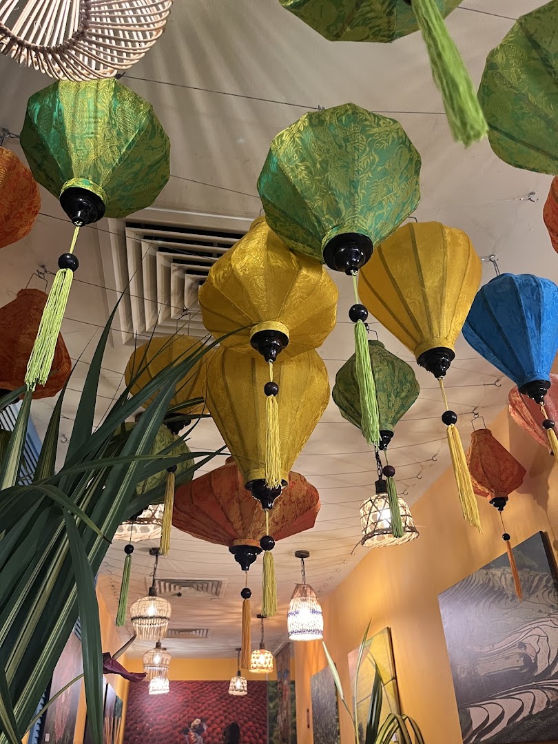 Colorful Vietnamese lanterns and lush greenery adorn the restaurant's interior ceiling, creating a vibrant ambiance.