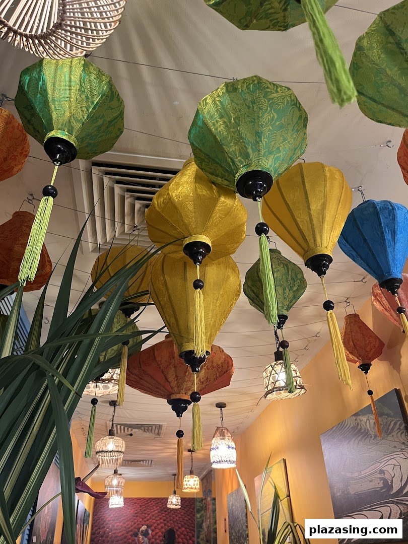 Colorful Vietnamese lanterns and lush greenery adorn the restaurant's interior ceiling, creating a vibrant ambiance.