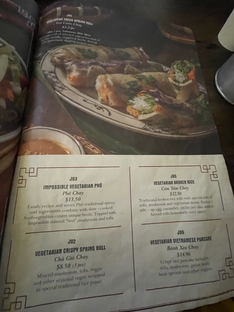 A close-up view of a Vietnamese restaurant menu featuring various vegetarian dishes with descriptions and prices.