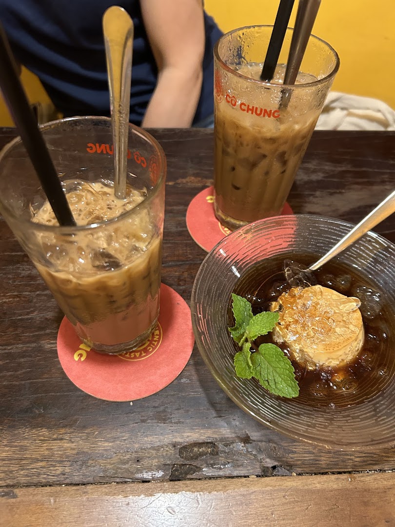 Two iced Vietnamese coffees and a traditional dessert with mint on a rustic wooden table.