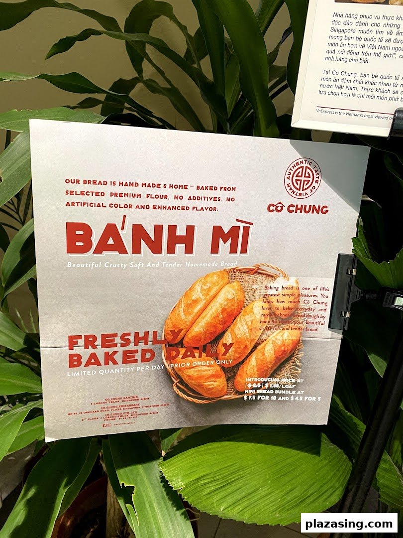 A promotional sign for Co Chung's freshly baked Bánh Mì bread, detailing ingredients and pricing.