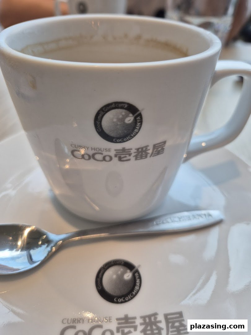 A white cup and spoon featuring the CoCo ICHIBANYA logo on a saucer.