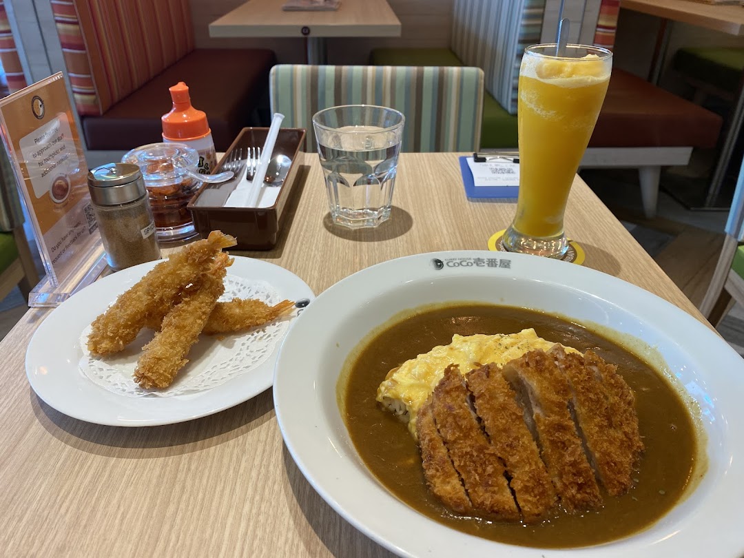 Delicious katsu curry with scrambled egg, fried shrimp, and a drink served at CoCo ICHIBANYA.