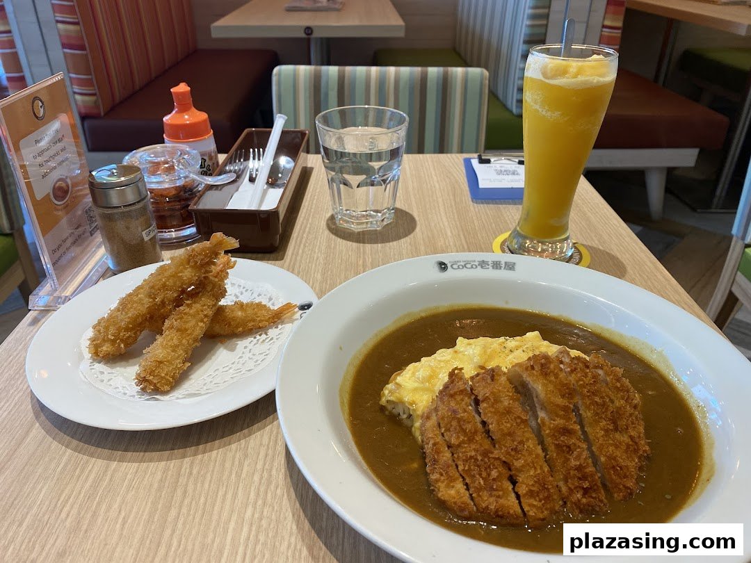 Delicious katsu curry with scrambled egg, fried shrimp, and a drink served at CoCo ICHIBANYA.