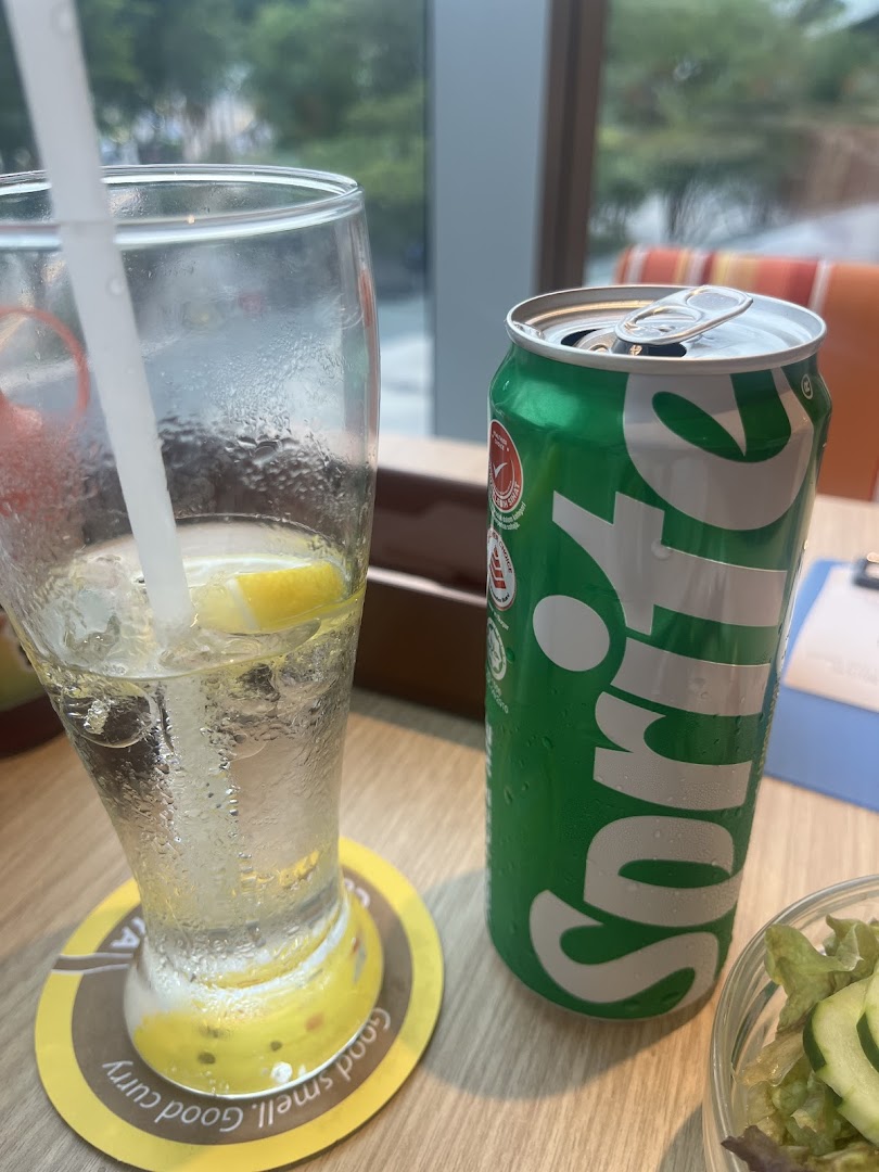 A refreshing Sprite can and a glass of iced lemon water on a CoCo ICHIBANYA coaster.