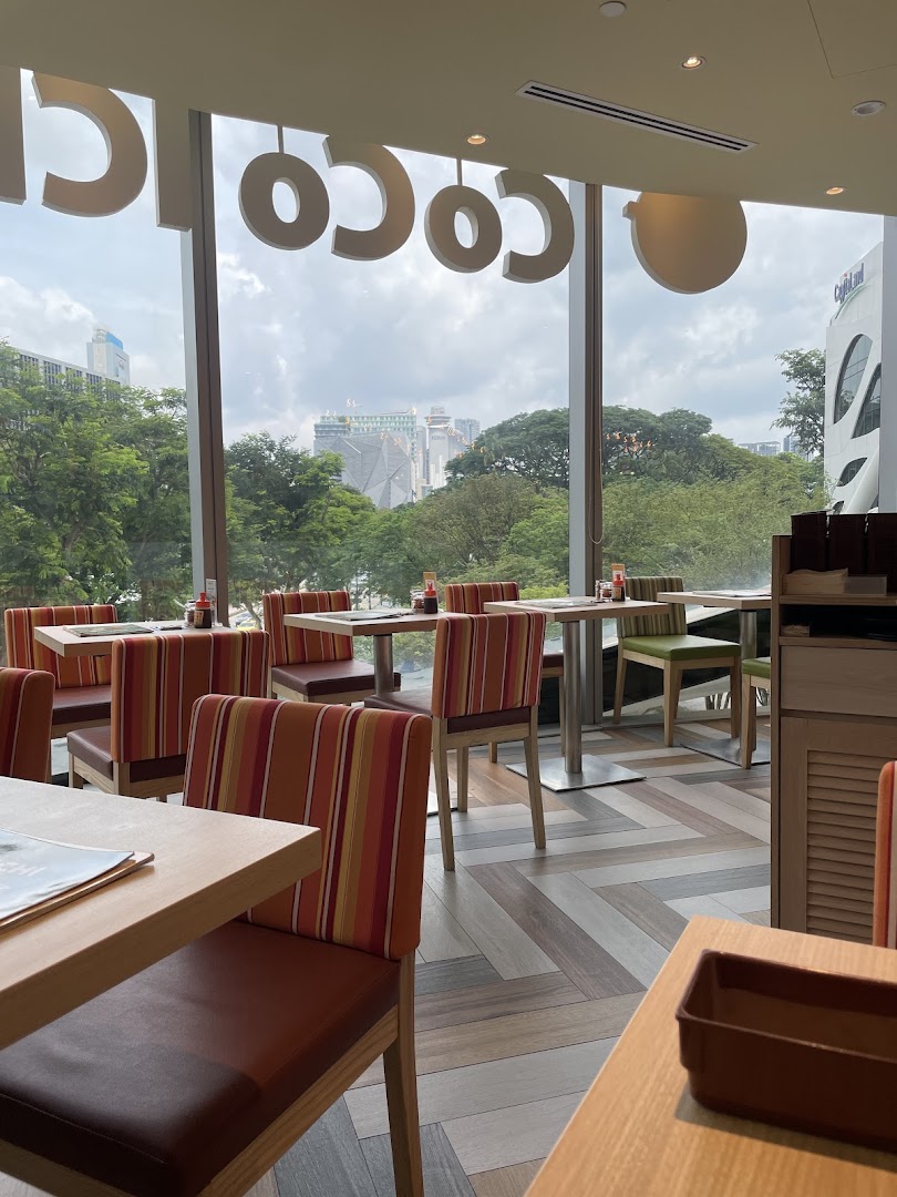 Spacious dining area at CoCo ICHIBANYA with comfortable seating and a scenic city view through large windows.
