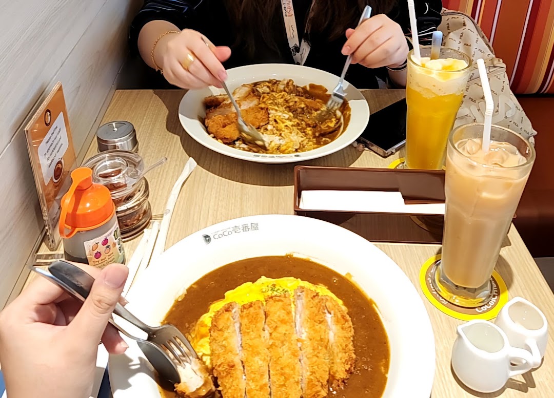 Customers enjoying delicious katsu curry and refreshing drinks at CoCo ICHIBANYA.