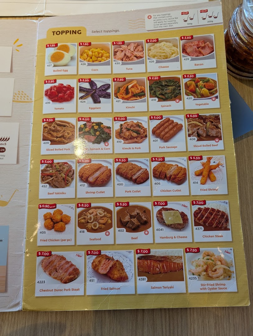 A detailed menu page from CoCo ICHIBANYA, showcasing a wide array of curry toppings and side dishes.