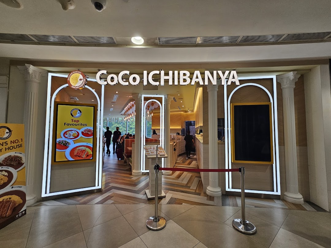 The brightly lit entrance of CoCo ICHIBANYA, a Japanese curry restaurant, with promotional displays.