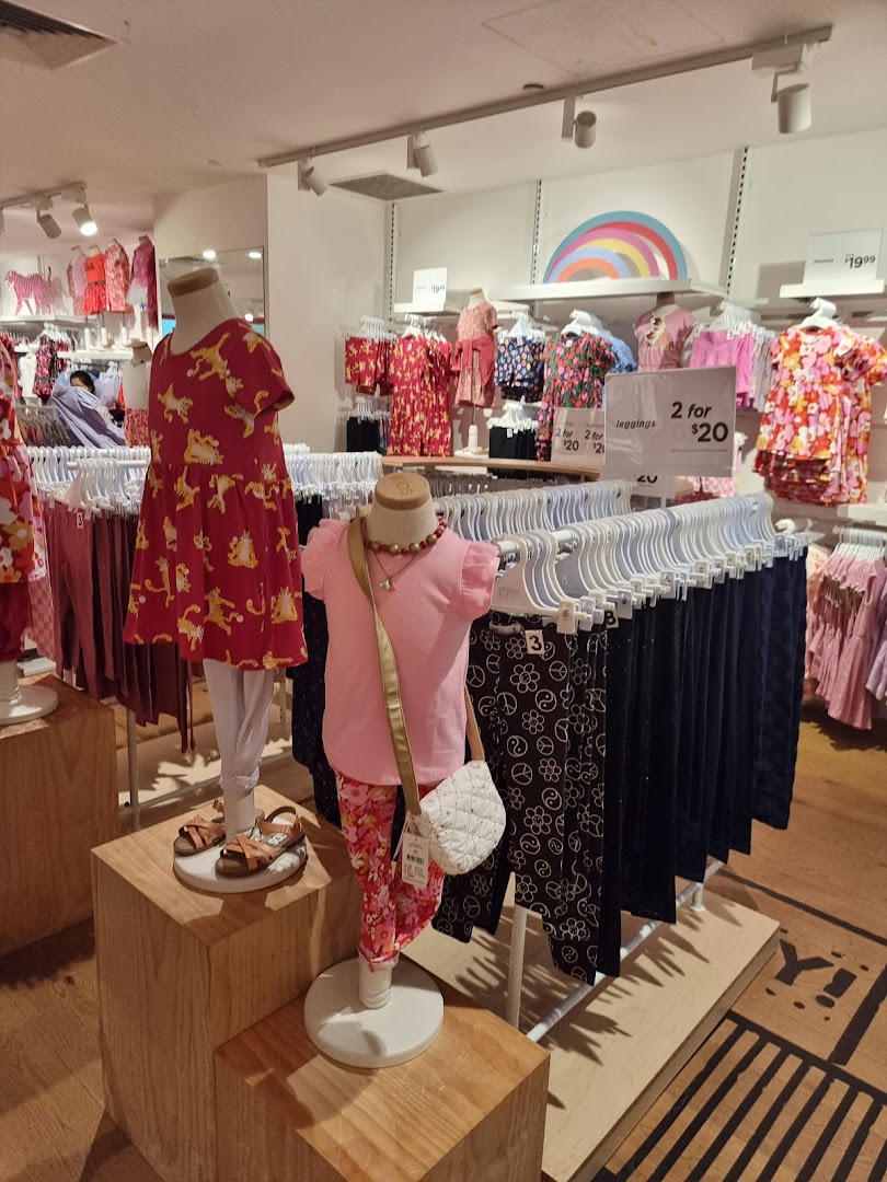 Colorful children's clothing displayed on mannequins and racks inside Cotton On Kids.