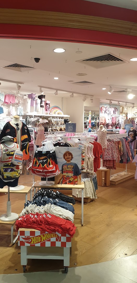 An interior view of Cotton On Kids, showcasing colorful children's apparel and Hot Wheels themed clothing displays.